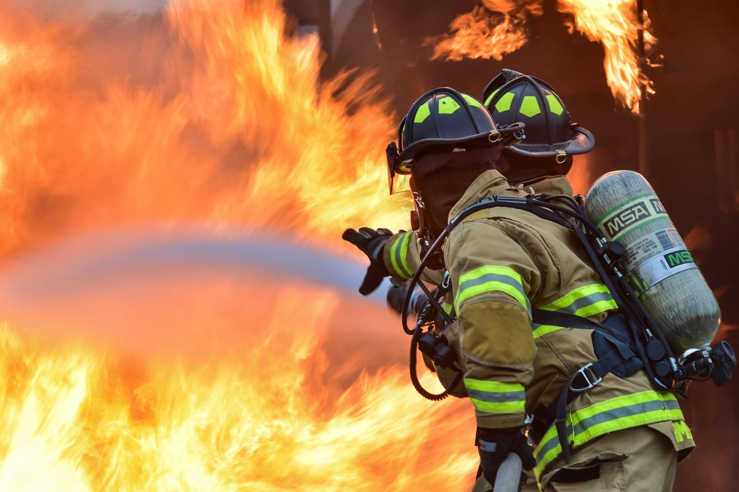 two firefighters hosing a fire