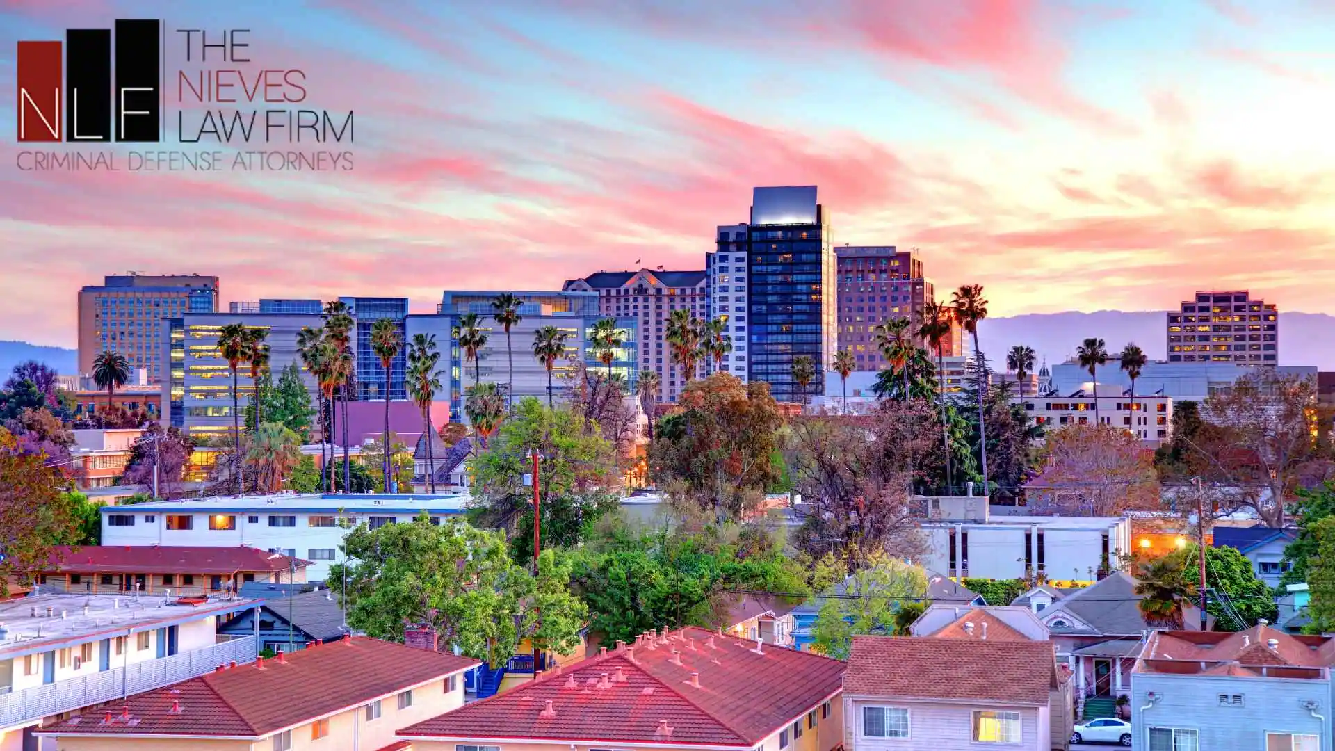 The San Jose, CA skyline at dusk, home to clients who turn to an assault lawyer in San Jose when criminal charges put their future at risk. Branded with The Nieves Law Firm, APC logo.