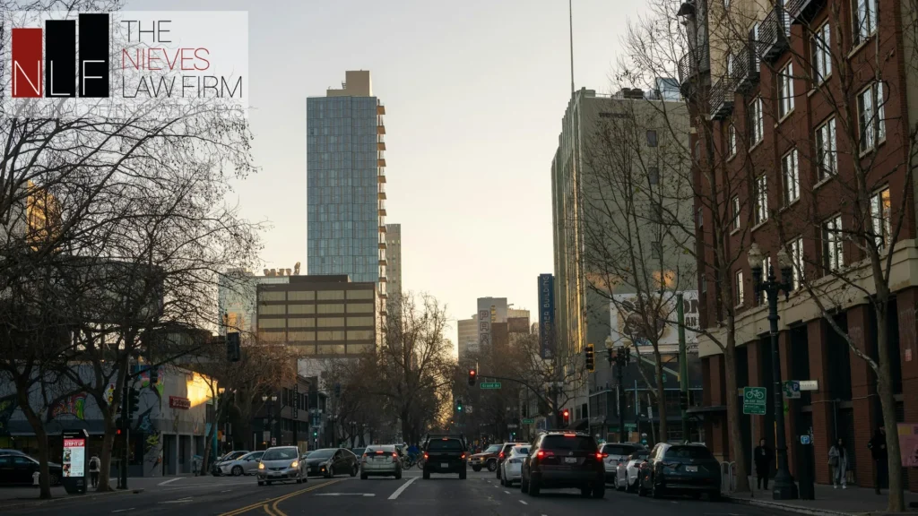Downtown Oakland street with high-rise buildings, with The Nieves Law Firm logo