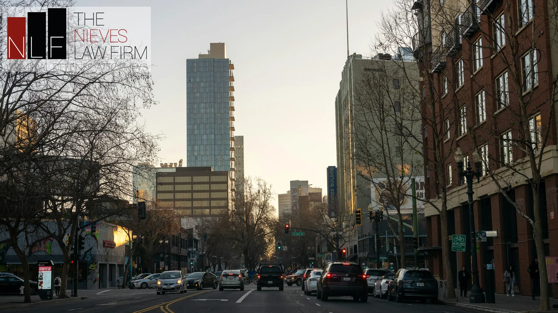 Downtown Oakland street with high-rise buildings, with The Nieves Law Firm logo