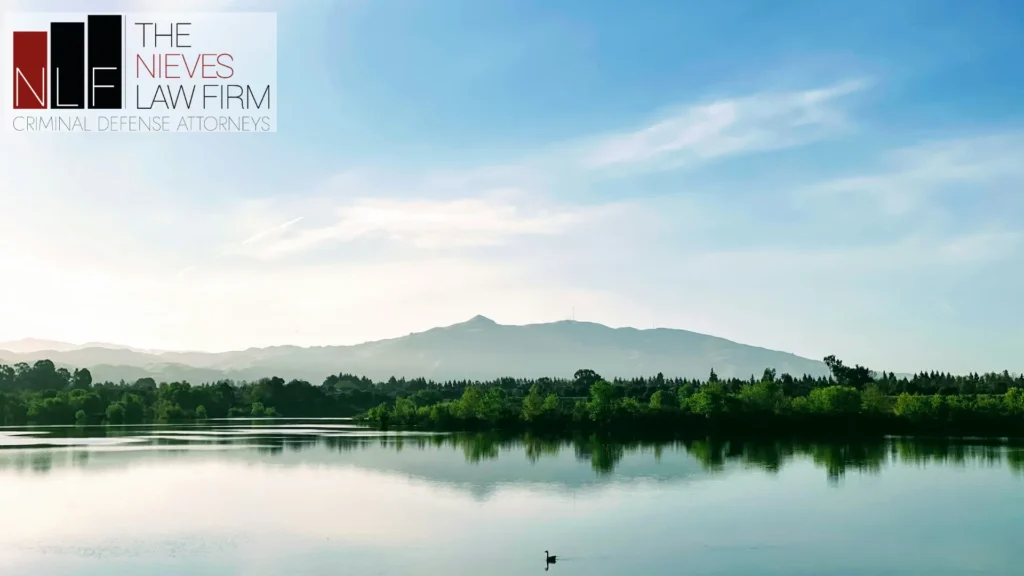 Calm lake in Fremont with the East Bay hills on the horizon, with The Nieves Law Firm logo