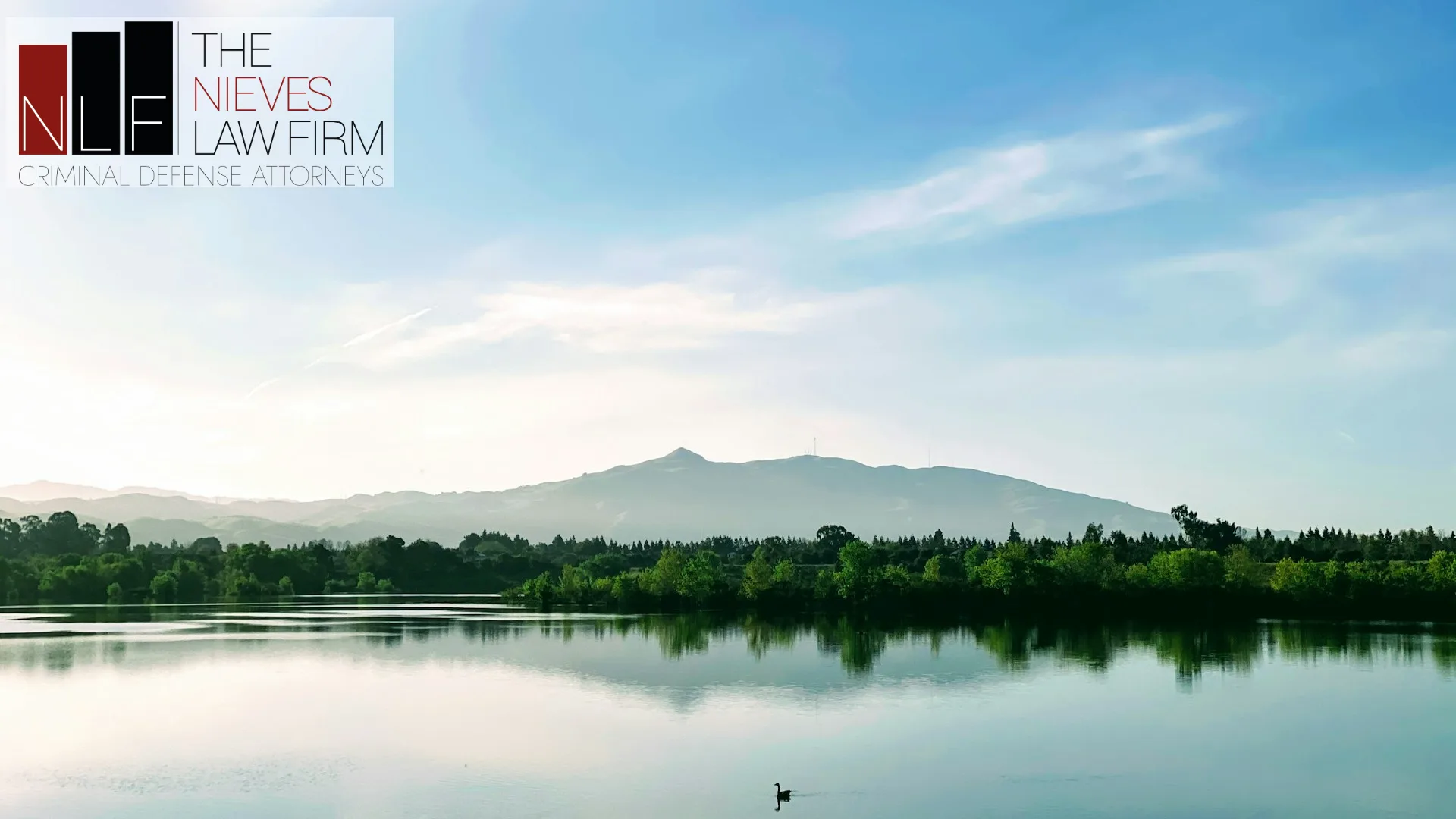 Calm lake in Fremont with the East Bay hills on the horizon, with The Nieves Law Firm logo