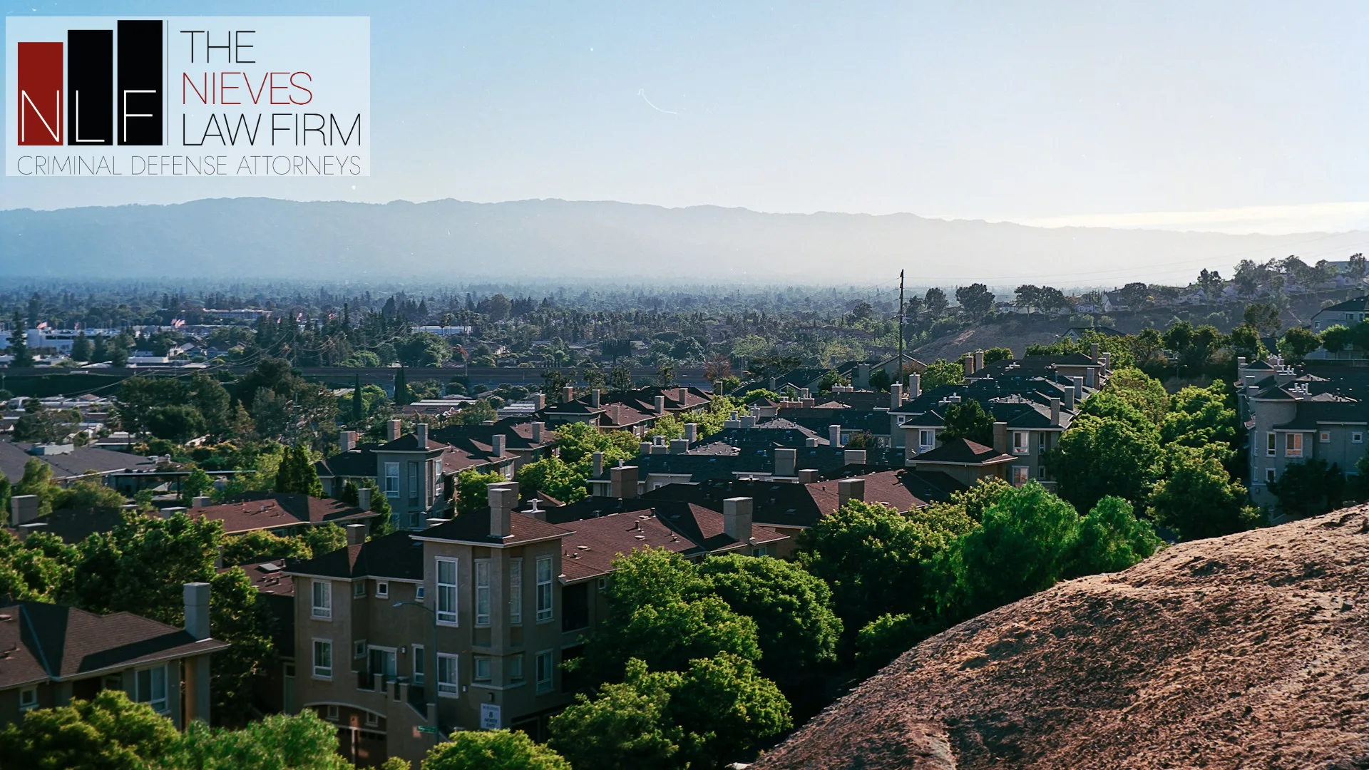 San Jose rooftops and the Santa Clara Valley seen from Communications Hill, with The Nieves Law Firm logo