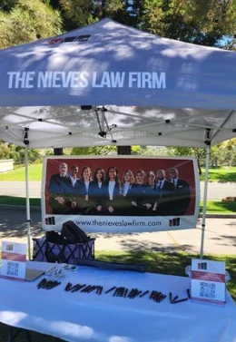 The Nieves Law Firm tent and giveaway table at the Philmore Graham Memorial Scholarship Golf Tournament
